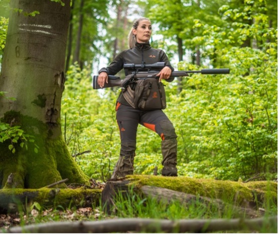 Hunter standing in woodland holding a rifle with a Vorn SR10 hip pack at the waist